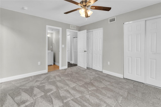 8640 Tahoe Ct Unit 16, Tampa, FL 33614 - unfurnished bedroom with two closets, carpet, baseboards, ensuite bath, and a ceiling fan