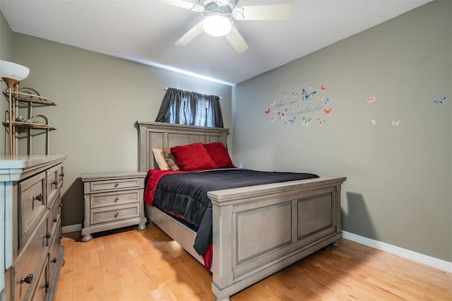 bedroom featuring baseboards, ceiling fan, and light wood-style flooring
