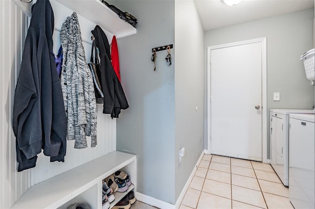 laundry area featuring light tile patterned floors, baseboards, laundry area, and washer and clothes dryer