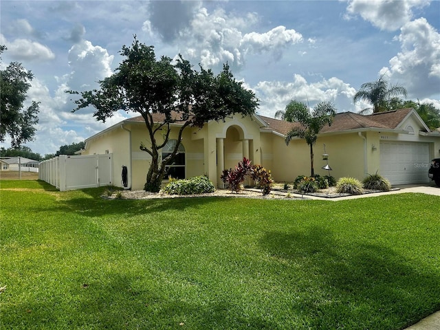 view of front of house with a garage, stucco siding, a front yard, and fence