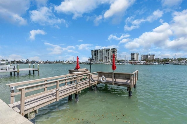 view of dock featuring a water view and a view of city