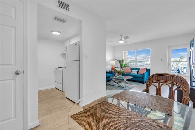 dining area with ceiling fan, light wood-type flooring, visible vents, and baseboards