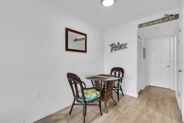 dining room featuring light wood-type flooring and baseboards