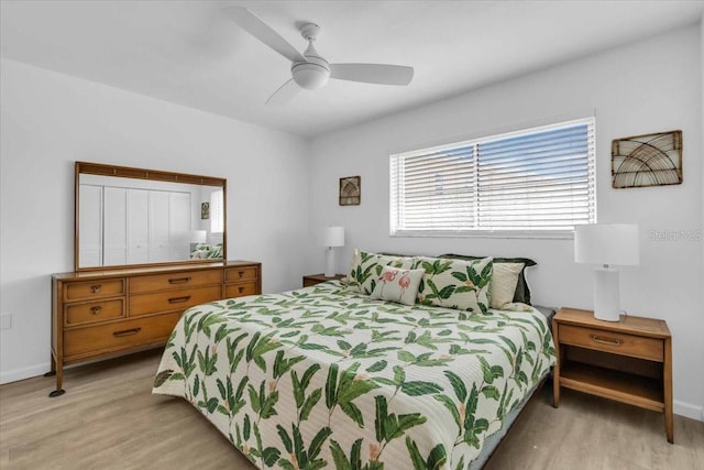 bedroom with light wood finished floors, a ceiling fan, and baseboards