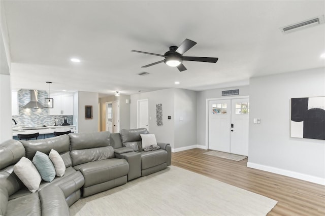 living area featuring recessed lighting, visible vents, light wood-style floors, ceiling fan, and baseboards