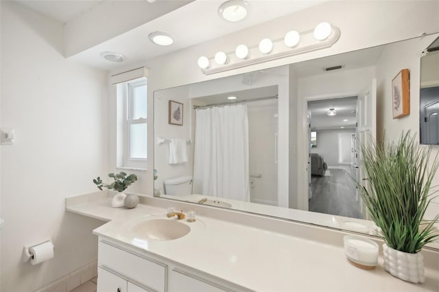 bathroom featuring baseboards, visible vents, toilet, curtained shower, and vanity