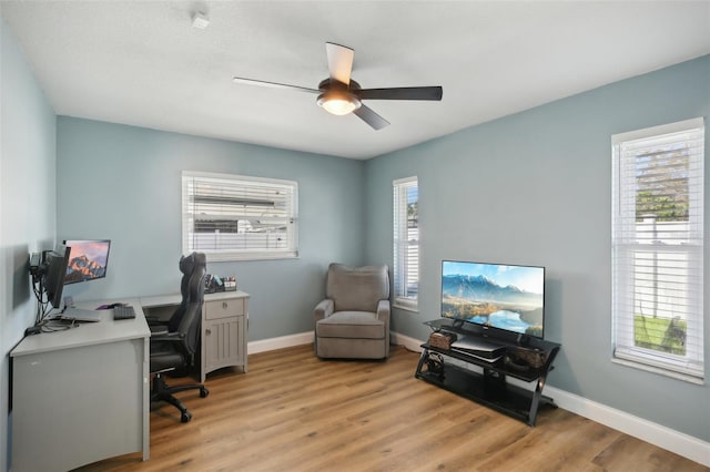 office featuring light wood-style flooring, baseboards, and a ceiling fan