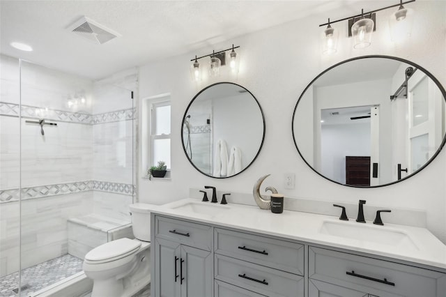 full bathroom with double vanity, a shower stall, visible vents, and a sink