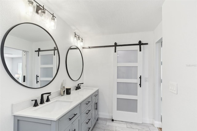 bathroom featuring double vanity, a textured ceiling, and a sink