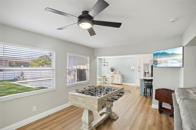 rec room featuring a ceiling fan, light wood-type flooring, and baseboards