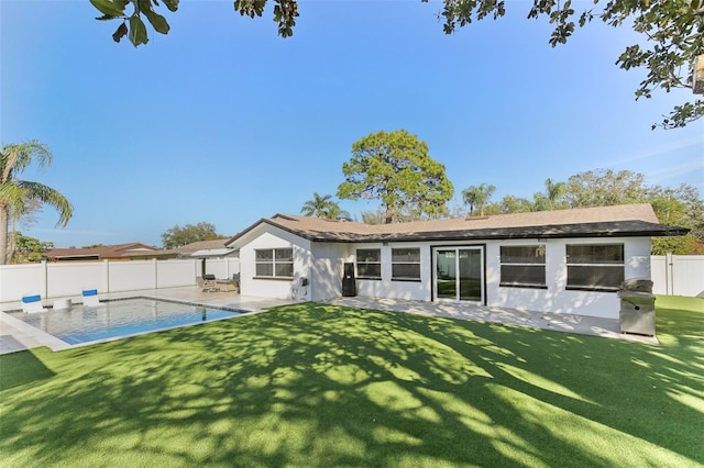 back of property with a fenced in pool, a yard, a patio, stucco siding, and a fenced backyard