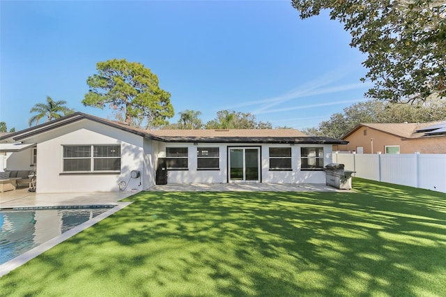 back of property with a fenced in pool, a yard, a patio, stucco siding, and fence