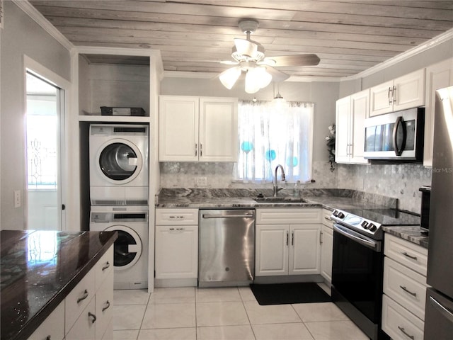 kitchen with crown molding, appliances with stainless steel finishes, a sink, and stacked washer and clothes dryer