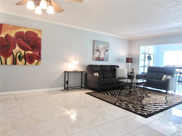 living area with a textured ceiling, tile patterned floors, a ceiling fan, and crown molding