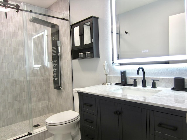 full bathroom with toilet, a stall shower, and vanity