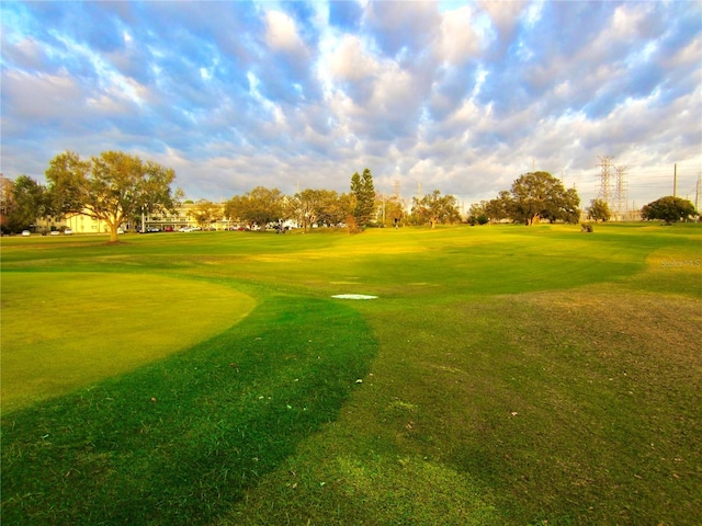 view of community featuring view of golf course and a lawn