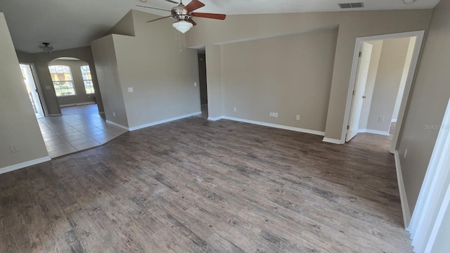 unfurnished room featuring baseboards, arched walkways, a ceiling fan, lofted ceiling, and wood finished floors