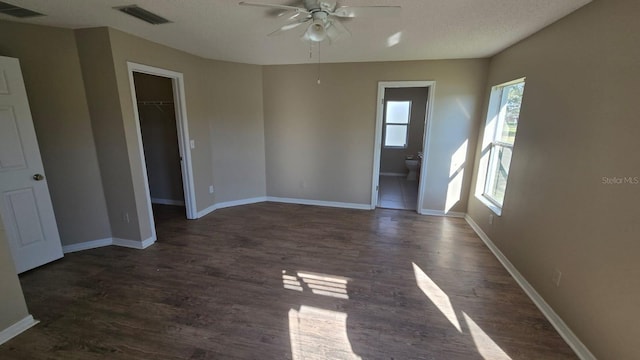 unfurnished room featuring dark wood-style floors, visible vents, and baseboards