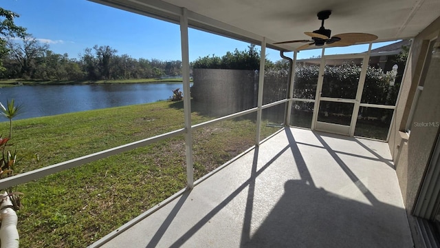 unfurnished sunroom featuring a water view and a ceiling fan