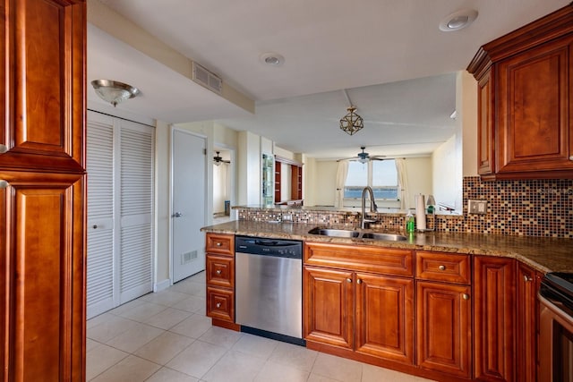 kitchen with a sink, visible vents, appliances with stainless steel finishes, backsplash, and dark stone countertops