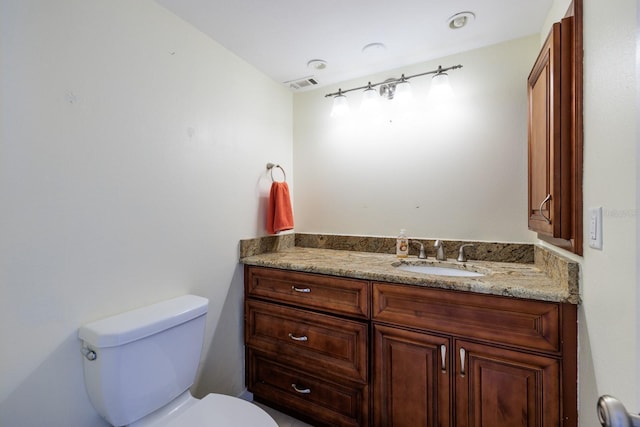 bathroom featuring visible vents, vanity, and toilet