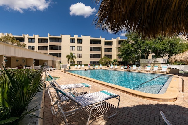 community pool with fence and a patio