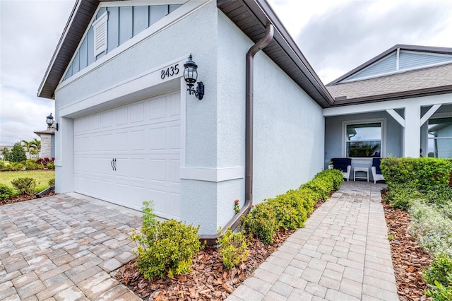 view of home's exterior with a garage, decorative driveway, and stucco siding