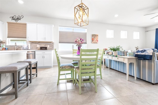 kitchen with light tile patterned flooring, white cabinetry, light countertops, decorative backsplash, and pendant lighting