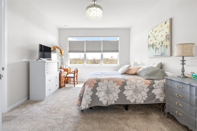 bedroom featuring carpet floors, baseboards, and an inviting chandelier