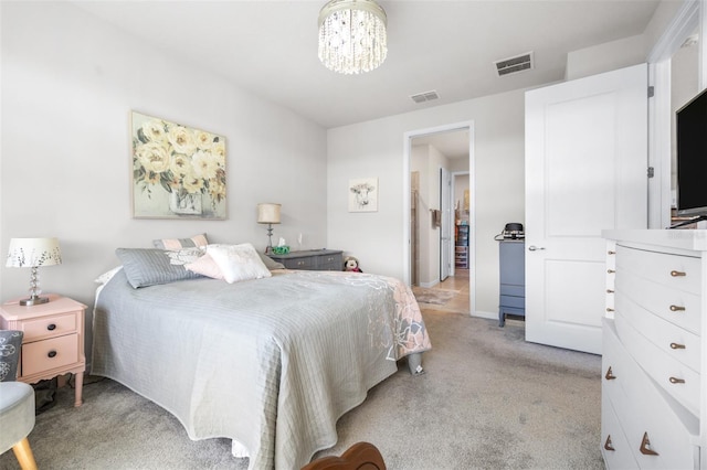 bedroom featuring light colored carpet, visible vents, and a notable chandelier