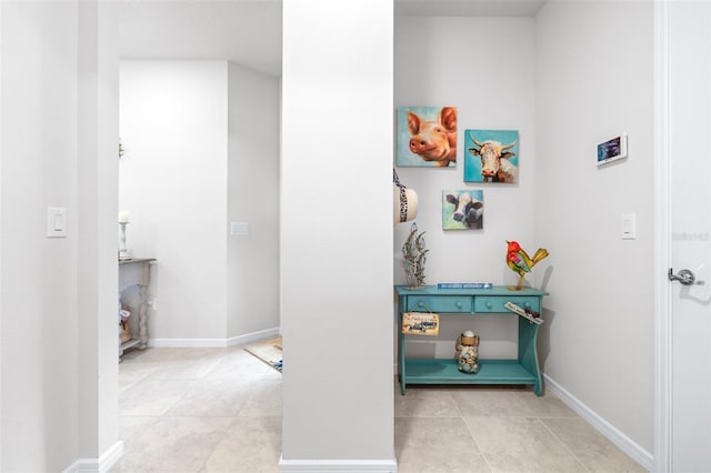 hallway featuring tile patterned flooring and baseboards