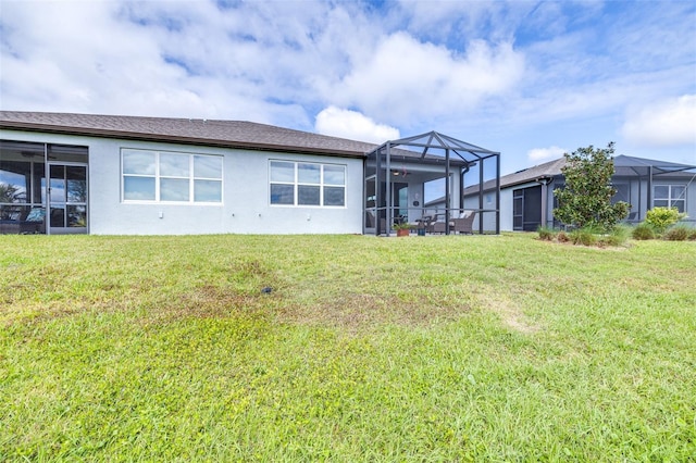 back of property with a lanai, a lawn, and stucco siding