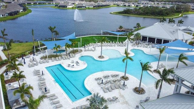 community pool with a water view and a patio area