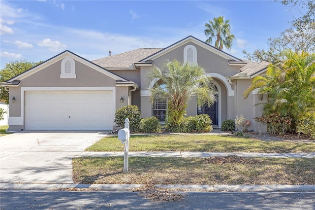 view of front of house with driveway, a garage, and stucco siding