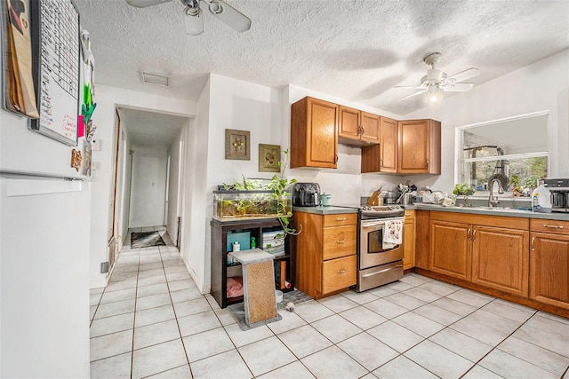 kitchen with a sink, light tile patterned floors, stainless steel electric stove, and a ceiling fan