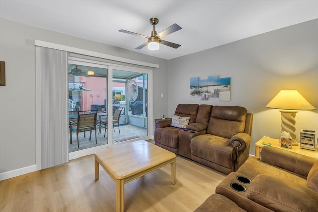 living area featuring light wood-style floors, ceiling fan, and baseboards