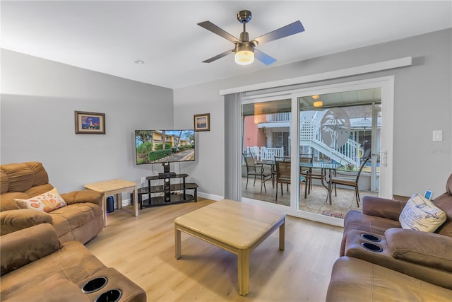 living area featuring light wood-style flooring, baseboards, and ceiling fan