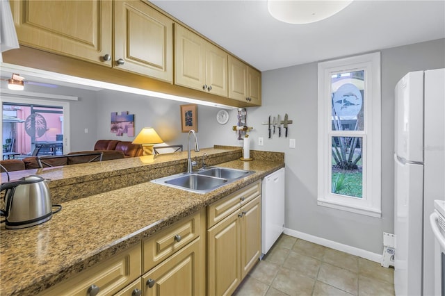 kitchen with light tile patterned flooring, white appliances, a sink, baseboards, and open floor plan