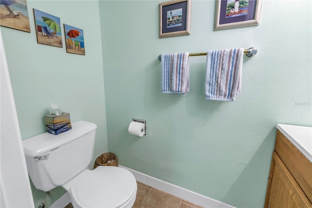 bathroom with tile patterned flooring, baseboards, vanity, and toilet