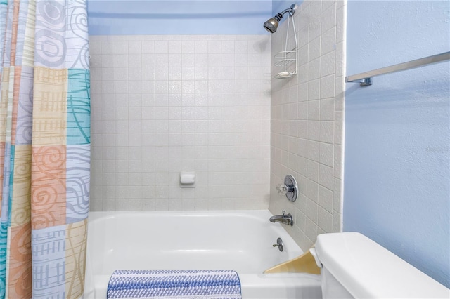 full bath with a textured wall, shower / tub combo, and toilet