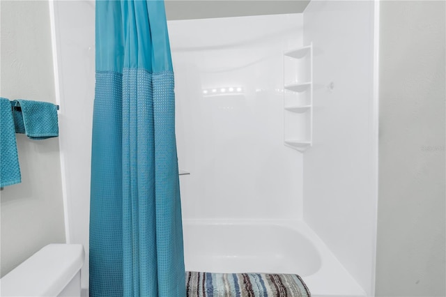 bathroom with toilet and shower / bath combo with shower curtain