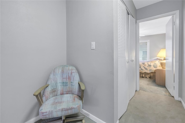 hall with baseboards and light colored carpet