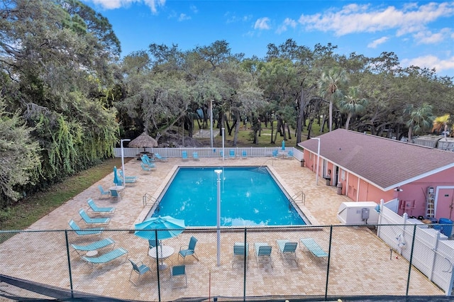 pool with fence and a patio