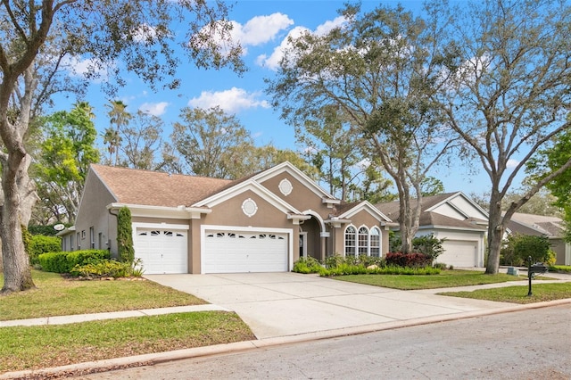 view of front of property with an attached garage, driveway, a front lawn, and stucco siding