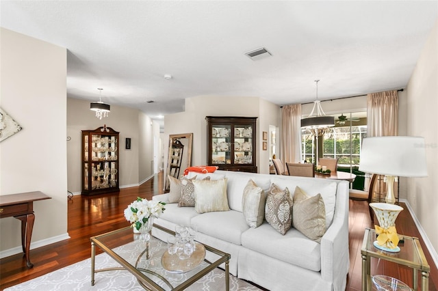 living room with visible vents, baseboards, and wood finished floors