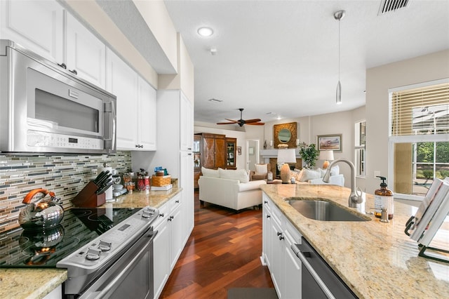 kitchen with visible vents, white cabinets, decorative backsplash, appliances with stainless steel finishes, and a sink