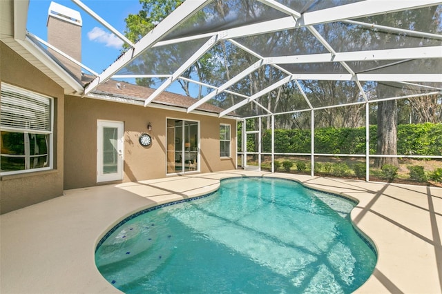 outdoor pool with glass enclosure and a patio area