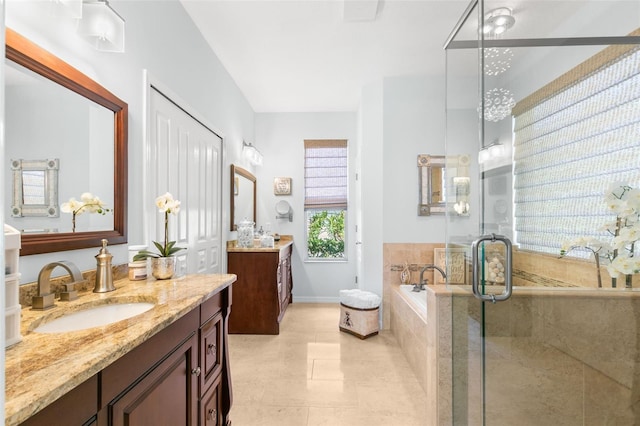 bathroom with a garden tub, two vanities, a sink, a shower stall, and tile patterned floors