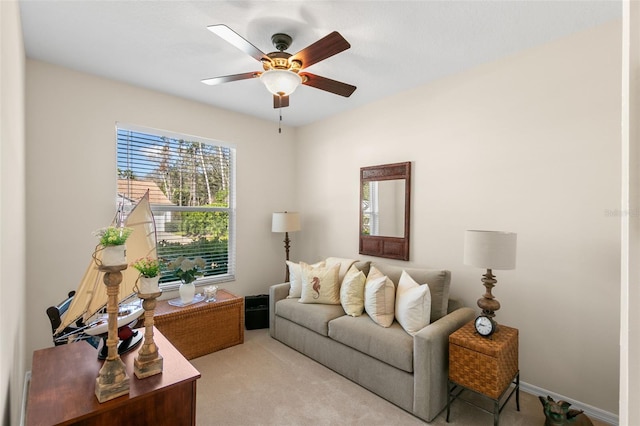 living room featuring light carpet, a ceiling fan, and baseboards