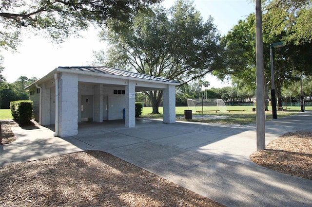 garage with an attached carport and concrete driveway